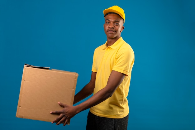 livraison-homme-afro-americain-polo-jaune-casquette-tenant-boites-carton-sourire-amical-debout-bleu-isole_141793-18677